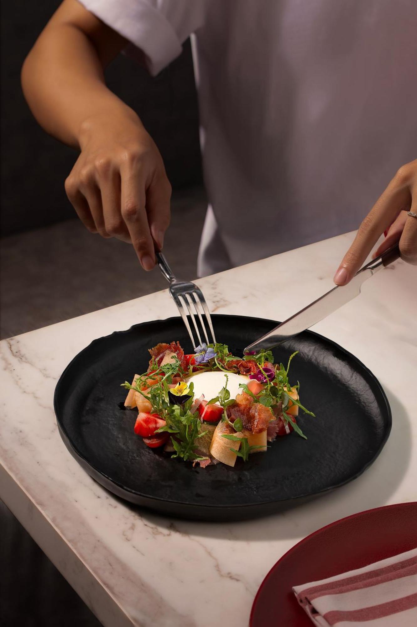 Melia Vinpearl Hue Hotel Bagian luar foto A salad being cut with a knife and fork